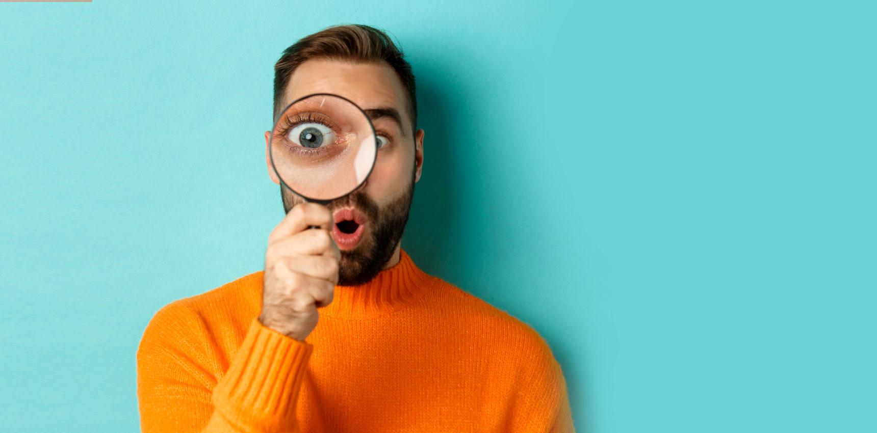Man with a magnifying glass to his eye